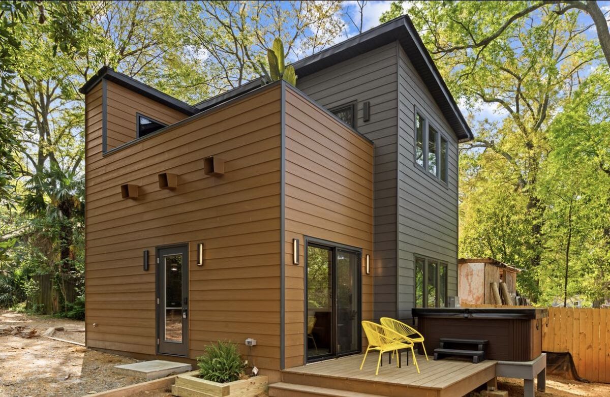 Two-story modern backyard ADU with brown and gray siding and a small deck, built in Atlanta